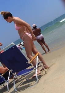 Sexy girl on the beach in a pink bikini