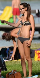 Couple sexy girls in bikinis getting sun at the lake