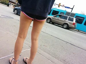 Girl in Slippers and Mini Shorts Legs Street Closeup