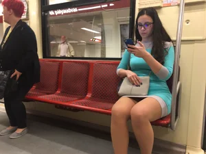 Candid Girl in Glasses And a Skirt Sitting in a Subway Train Photo