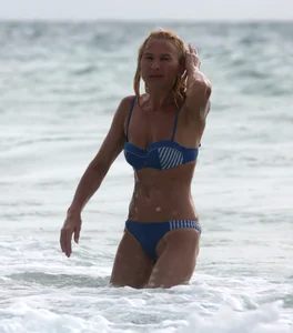 Blonde milf in a blue bikini looking sexy at the beach
