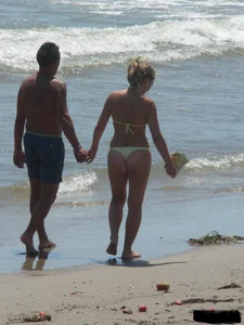 Sexy blonde on the beach in a yellow thong bikini