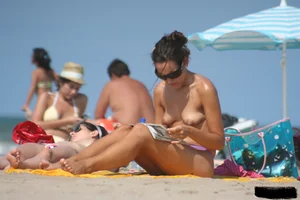 2 topless girls at the beach in thongs