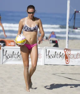 Hot girls playing beach volleyball in bikinis and shorts