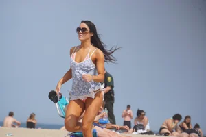 Trio of girls in bikinis on the beach and one with an incredible ass