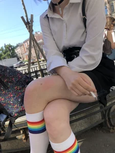 Two candid teens smoking on the street bench