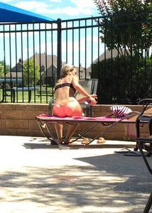 Blonde at the pool and laying out in peach and black bikini combo