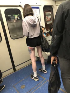 A Tall And Slim Candid Girl in Spandex Shorts in a Hoodie Top, With Tattoos on Her Long Legs Subway Creepshots