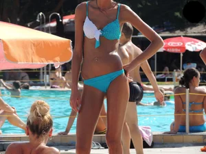 Tall and skinny brunette babe at the pool in a teal thong bikini