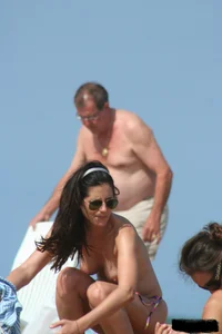 2 topless girls at the beach in thongs