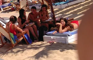Thick brunette on the beach with friends in red bikini