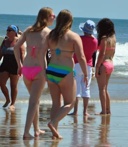 Two beach friends in bikinis one with back dimples and the other thick