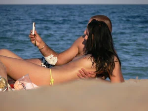 Topless beach babe with nice tits and ass in blue thong bikini
