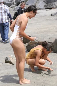 Sexy brunette babe on the beach in a white swimsuit