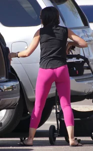 Milf brunette in purplish-pink leggings looking sexy in the parking lot