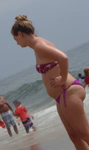 Milf booty in a purple bikini at the beach