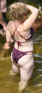 Chunky blonde enjoying some drinks in the water in her purple bikini