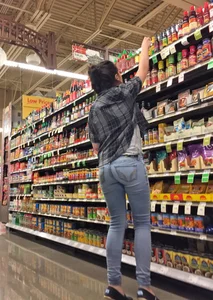 Sexy brunette grocery shopping in tight jeans