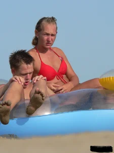 Sexy mom and daughter in red thongs at the beach