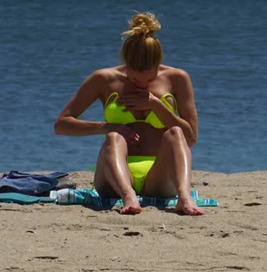 Sexy ass blonde milf on the beach in a thong with cameltoe and bending over