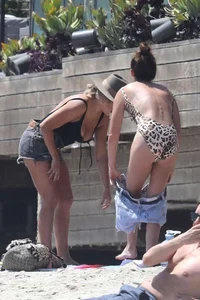Ashley Tisdale in cheetah print swimsuit on the beach in Malibu