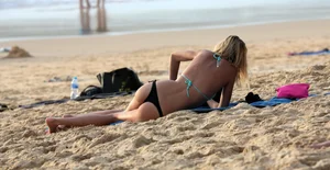 Sexy blonde laying out in black thong bikini