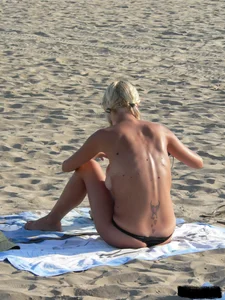Blonde on the beach topless with big boobs and in a black thong