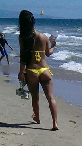Beach babe with a nice ass and big tits in yellow thong bikini