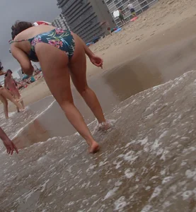 Cute lady at the beach with a nice body in a floral swimsuit