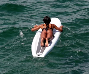 Black girl on the beach in a bikini with an incredible ass while surfing