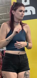 Tattooed girl with pierced nips and cheeks hanging out