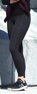 Brunette with glasses on the phone in tight patterned leggings
