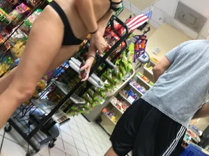 Candid blonde chick in a store in a black thong bikini
