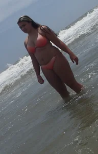 Thick beach girl with big boobs in a peach bikini