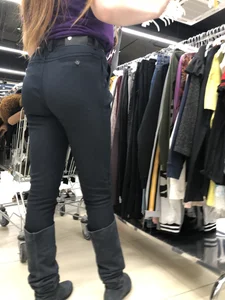 Cute candid shop assistant wearing boots and tight pants
