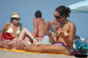 2 topless girls at the beach in thongs