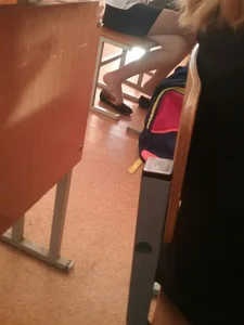 Crossed Slim Legs of a Young College Girl in a Skirt - Dangling Her Flats