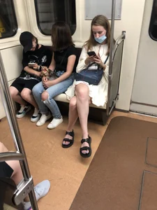 Masked Girl in a Dress and Sandals Sitting With Crossed Legs in a Subway Train Creepshots