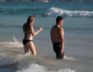 Cute bikini girl in the water in a black bikini