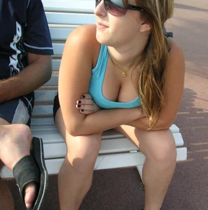 Girl leaning over to show off her nice tits while sitting on a bench