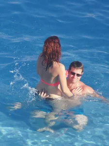 Sexy red haired girl in pink and black bikini at the pool