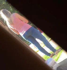 Girl wearing tight blue jeans in the backyard creepshots