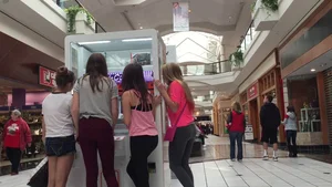 Little blonde teen in grey leggings at the mall with her friends