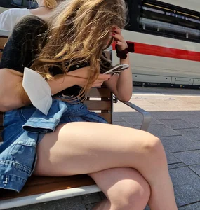 Candid Teen Girl With Awesome Legs in Shorts Sitting With Crossed Legs at the Railway Station Creepshots
