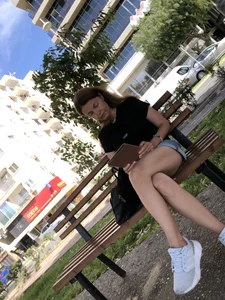 Candid chick with hot long legs sitting on the bench with crossed legs in shorts
