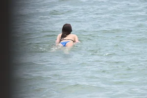 Skinny and sexy brunette on the beach in black and blue bikini