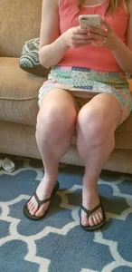 Milf in a Skirt and Slippers Sitting on the Couch Revealing Lacey Panties