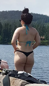 Thick brunette at the lake in a black thong bikini