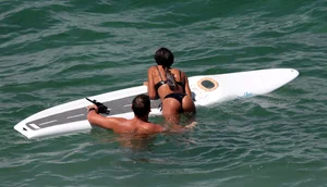 Black girl on the beach in a bikini with an incredible ass while surfing