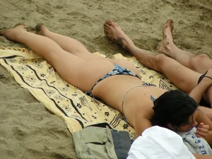 Sexy girl in a blue floral thong bikini at the beach